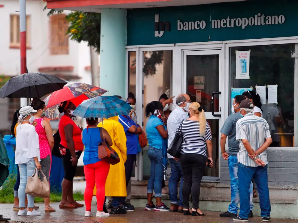 Varias personas hacen fila para entrar en un banco en La Habana